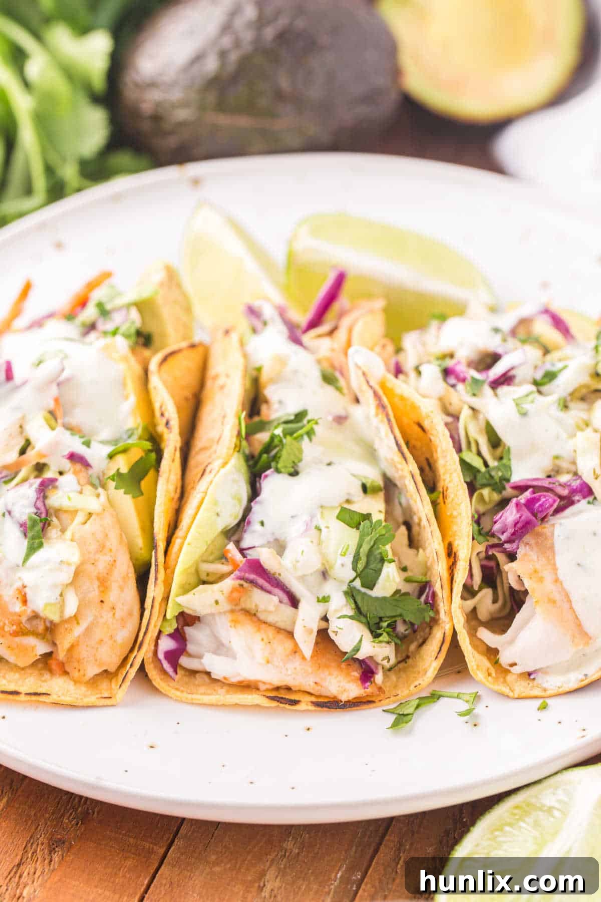 A vibrant plate of fish tacos, richly topped with fresh ingredients and creamy sauce.