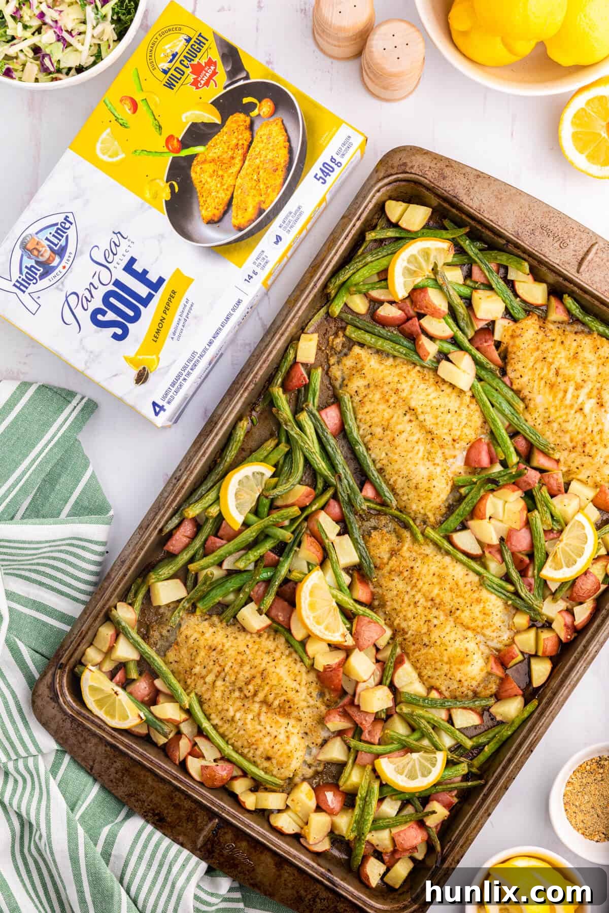 A beautifully plated Lemon Pepper Sole Sheet Pan Dinner with the High Liner product box visible beside it, showcasing the convenience and deliciousness of the meal.