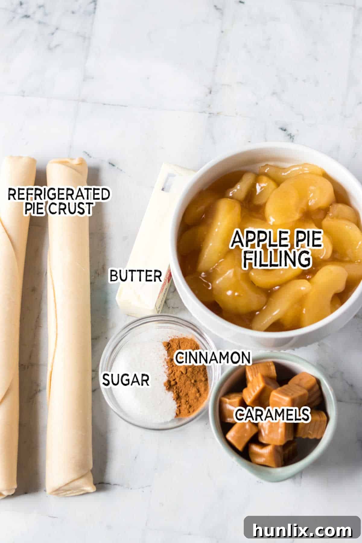 All the ingredients for Copycat Taco Bell Air Fryer Caramel Apple Empanadas displayed on a stylish marble background.