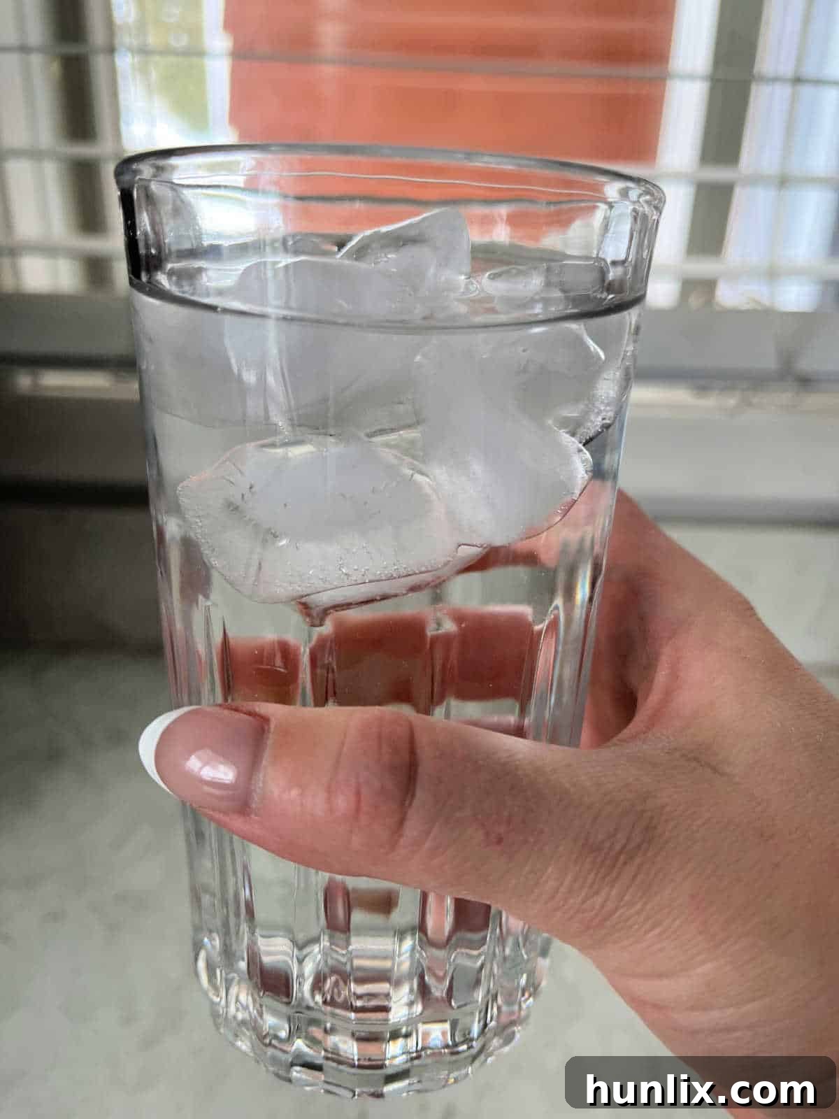 5 Daily Practices for a Vibrant Life 7 A hand on a glass of ice water.