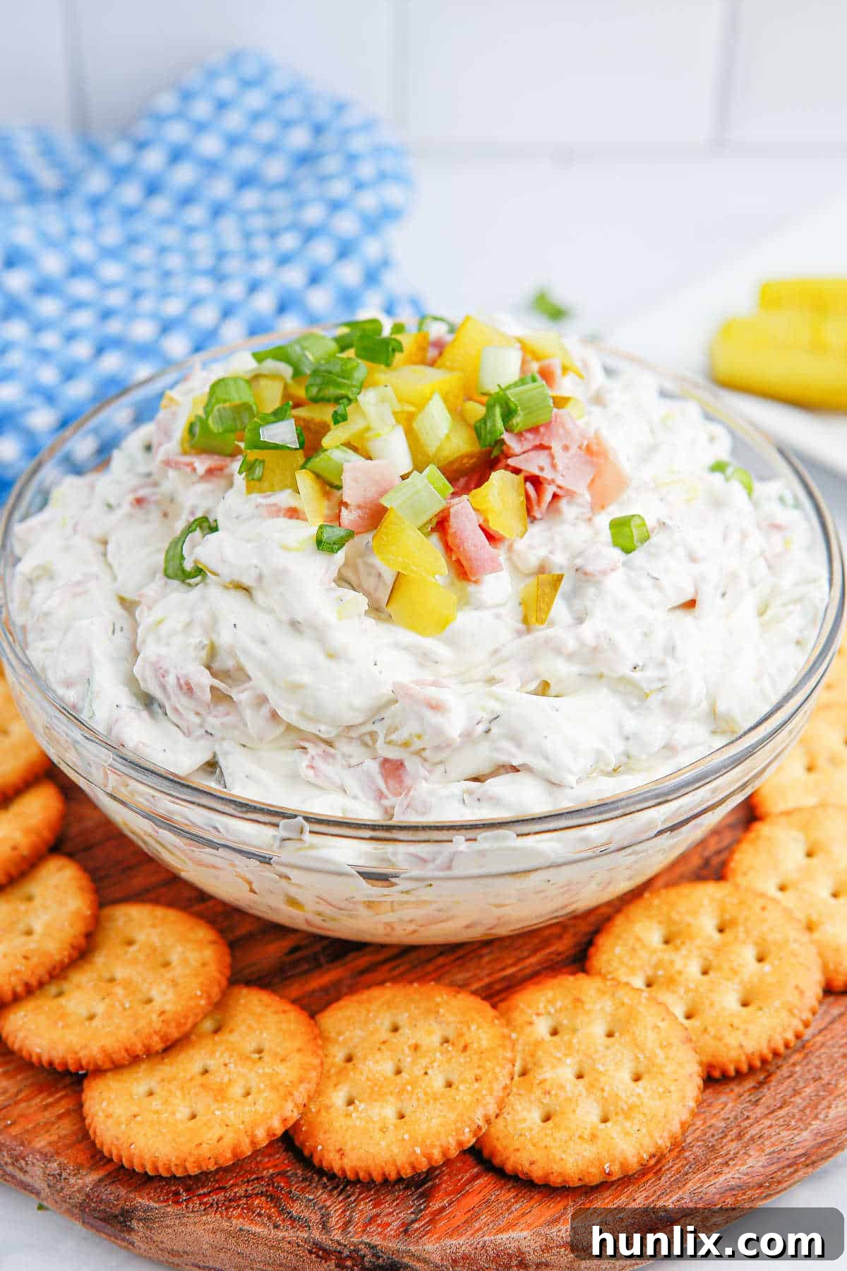 A beautifully presented bowl of creamy dill pickle dip, ready for serving, surrounded by a variety of crispy crackers and fresh vegetable sticks, highlighting its appeal as an appetizer.