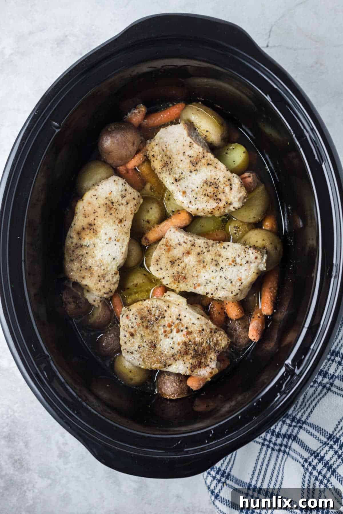 Italian pork chops and veggies in a Crockpot, showcasing a perfect weeknight meal.