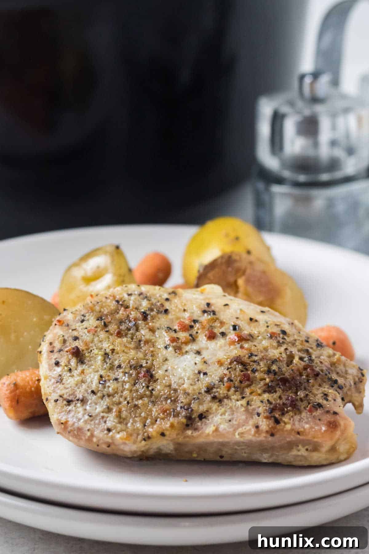 A perfectly cooked Italian pork chop with vegetables on a white plate, ready to be enjoyed.