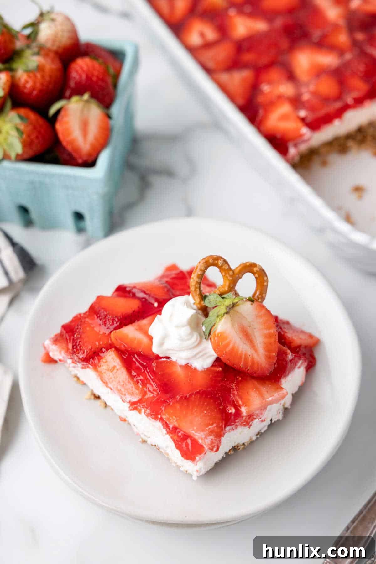 A slice of strawberry pretzel salad on a plate.
