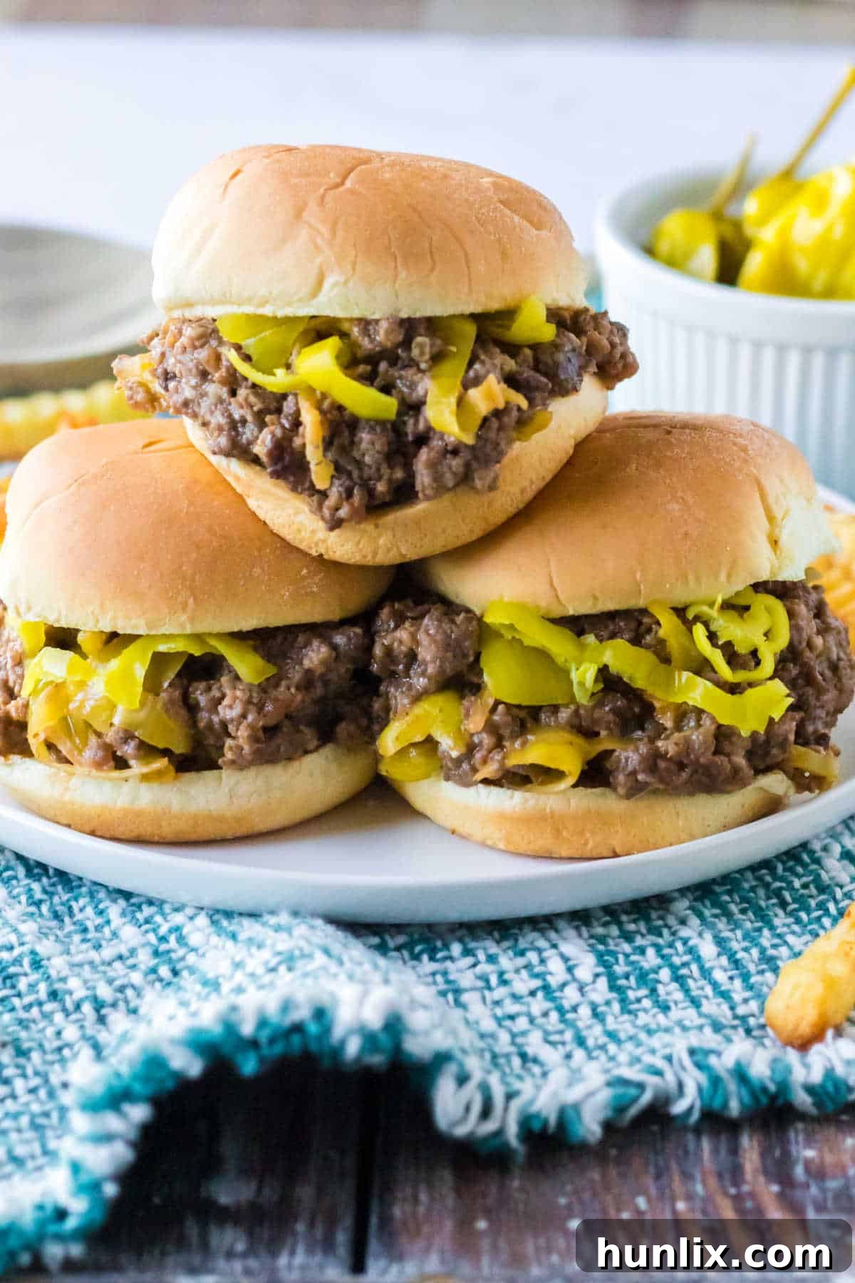 Hearty Slow Cooker Mississippi Sloppy Joes 6 A plate piled high with delicious Mississippi Sloppy Joes on toasted buns, ready to be enjoyed.