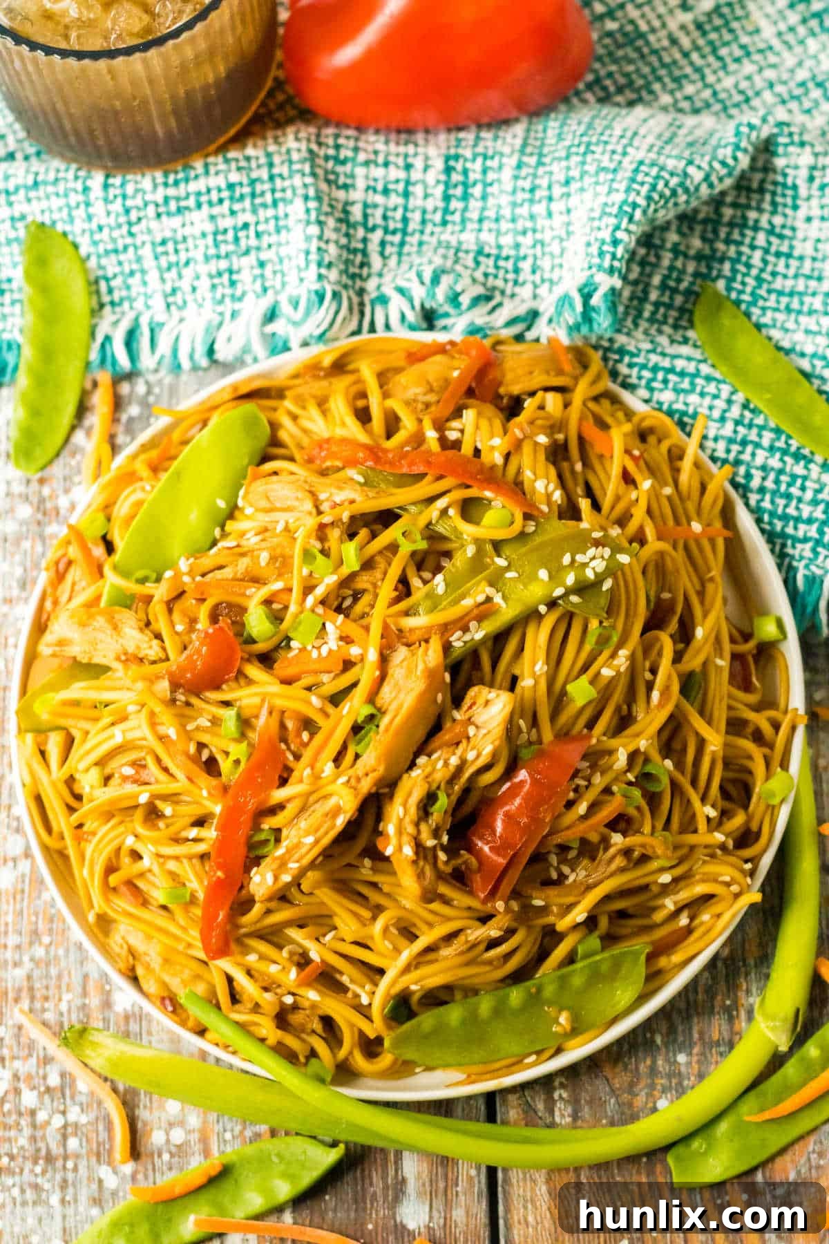 Close-up of a plate of slow cooker chicken lo mein with visible toppings.