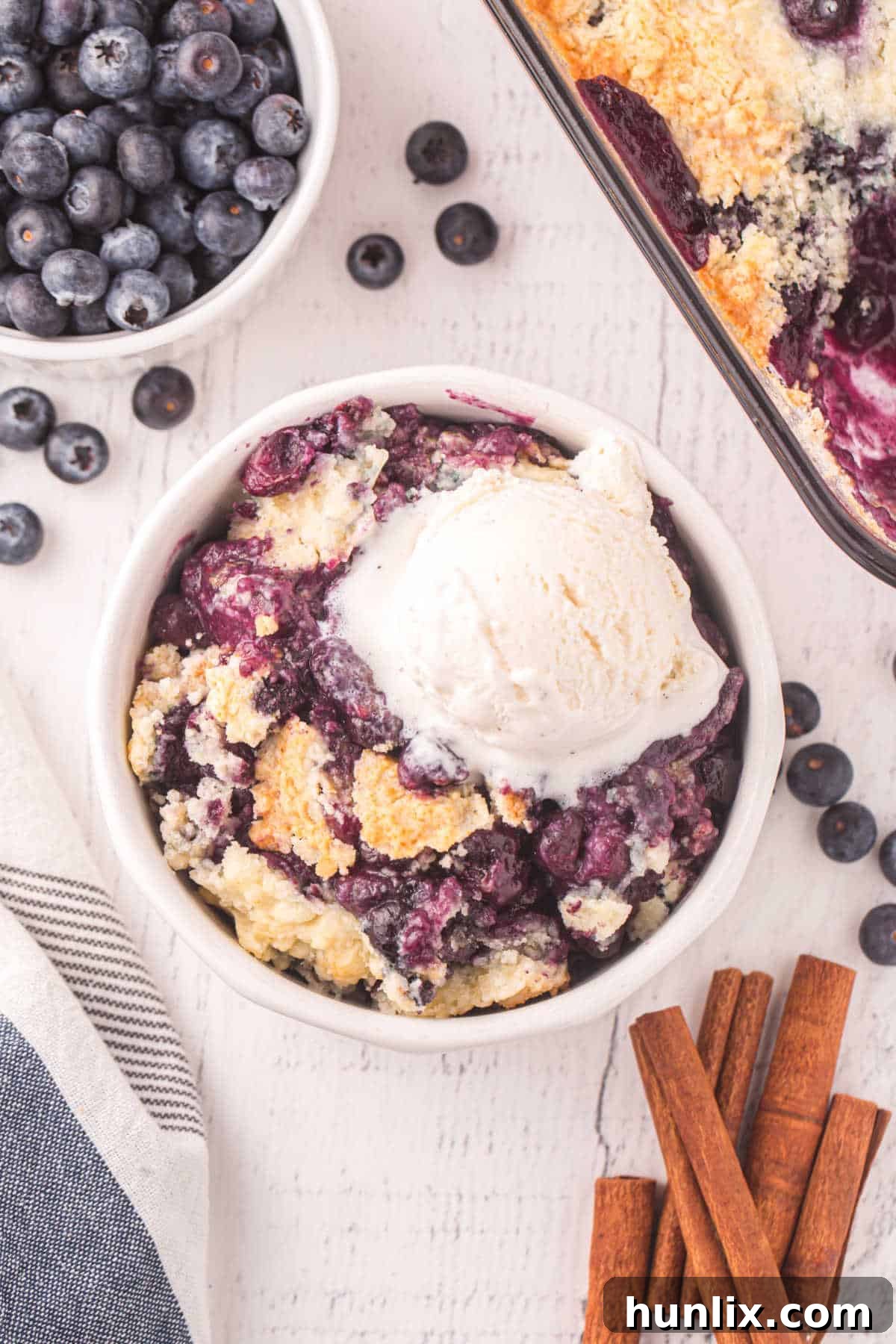 Bursting Blueberry Bliss 7 Blueberry cobbler in a bowl with vanilla ice cream.