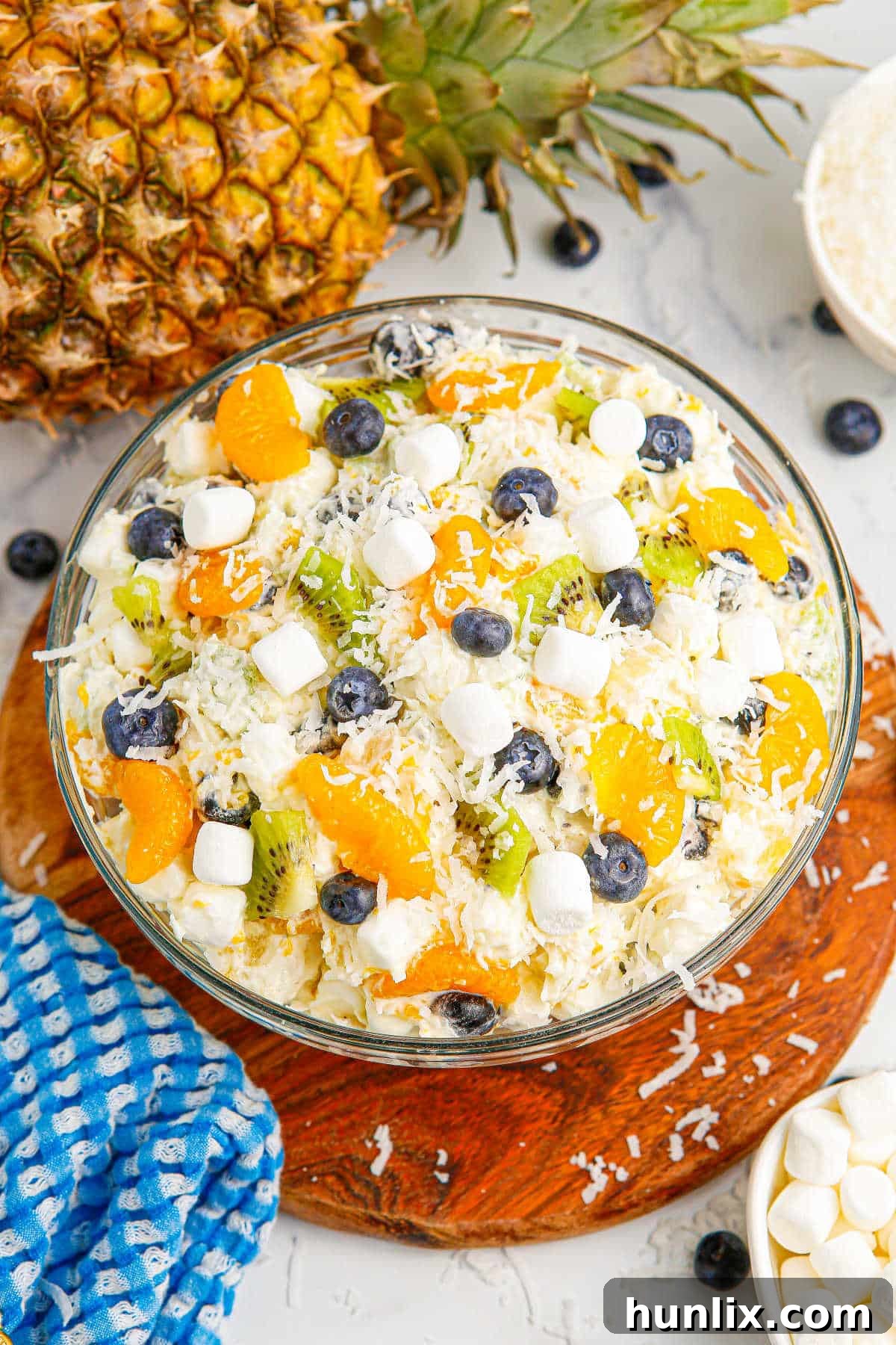 Tropical Cloud Delight 2 A beautifully presented bowl of Tropical Fluff Salad, garnished with fresh fruit, showcasing its vibrant colors and creamy texture, perfect for any summer gathering or potluck.