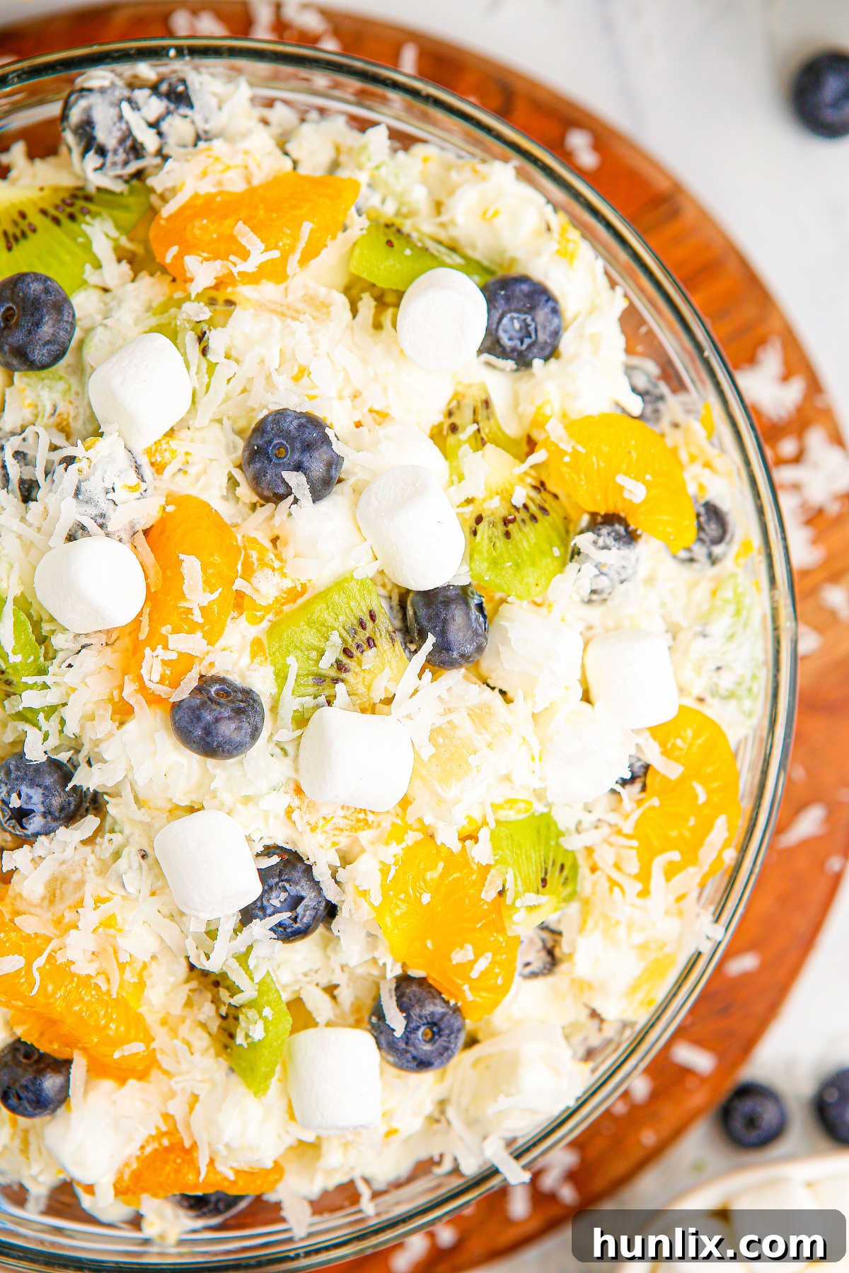 Tropical Cloud Delight 5 A large glass bowl filled with vibrant Tropical Fluff Salad, ready to be served, highlighting its appealing colors and textures for a party or meal.