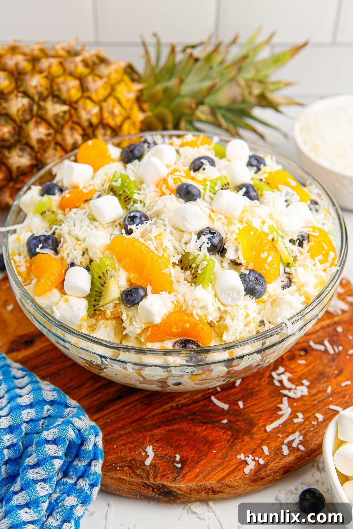 Tropical Cloud Delight 6 A close-up shot of Tropical Fluff Salad in a bowl, showing its creamy texture and visible fruit pieces, emphasizing its deliciousness.