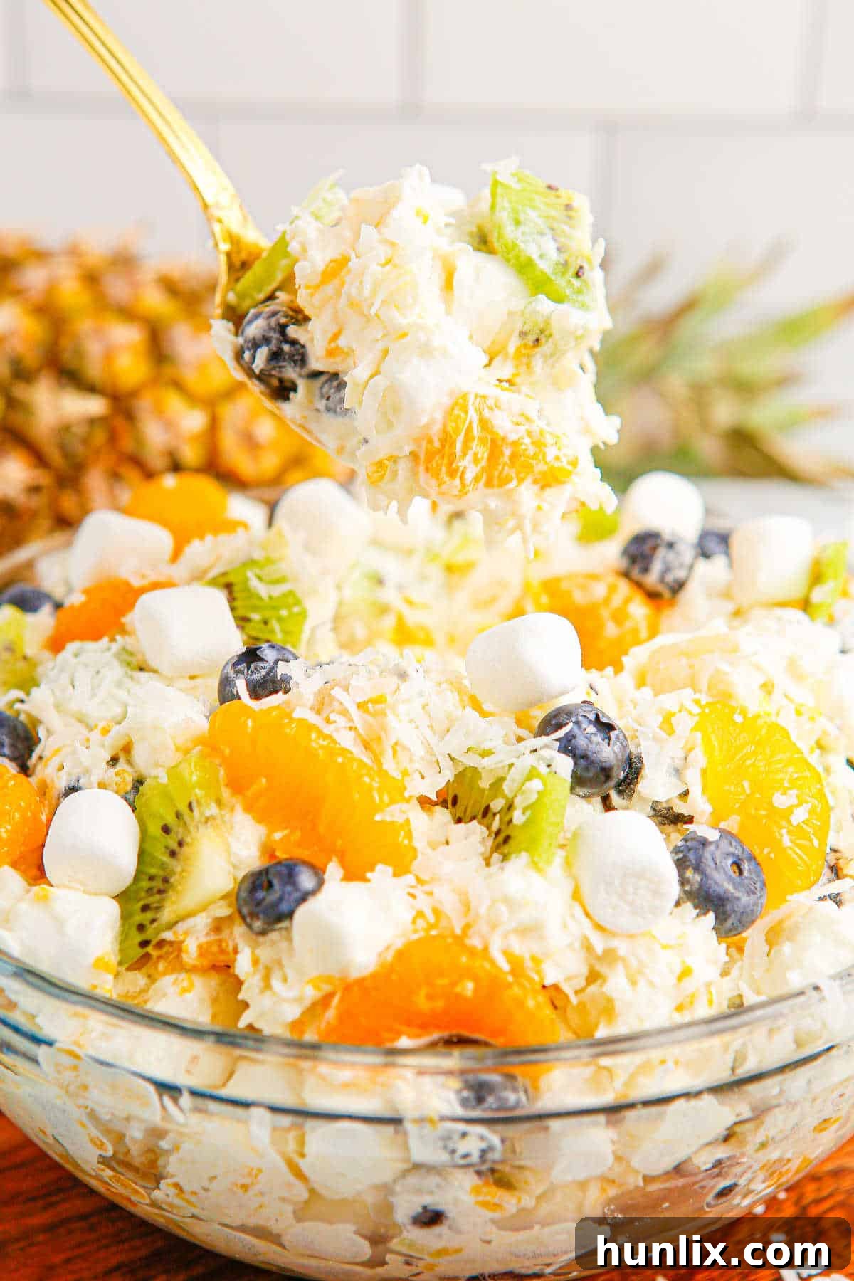 Tropical Cloud Delight 7 A close-up of a spoonful of Tropical Fluff Salad, showing the creamy mixture, fruit pieces, and mini marshmallows, ready to be enjoyed.