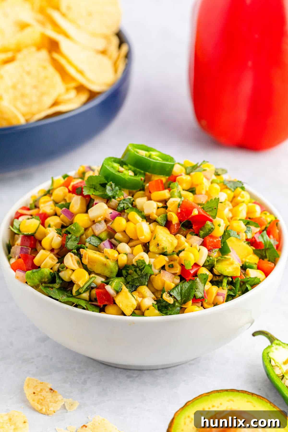 Zesty Corn Salsa 7 A bowl of fresh corn salsa on a table with a rustic background.