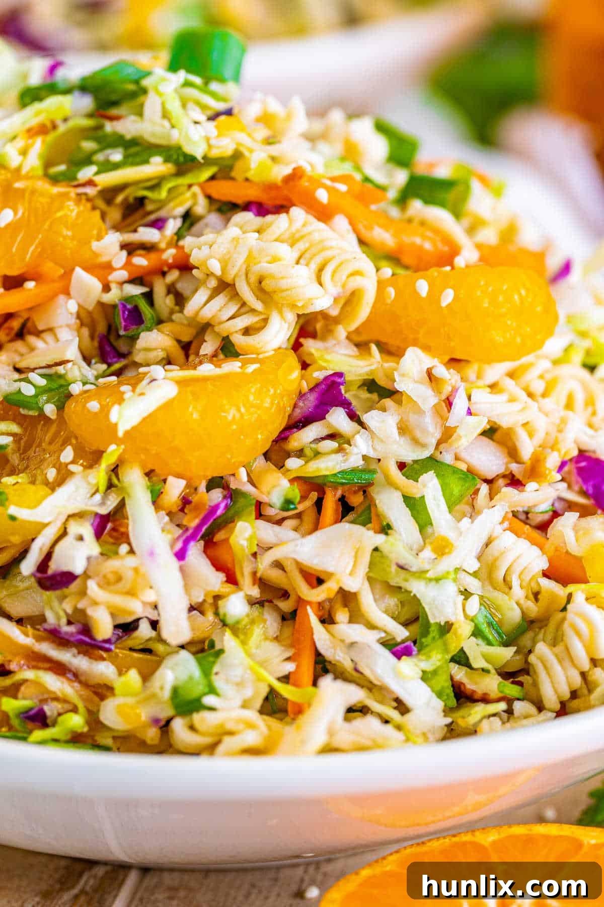 A serving of ramen noodle salad on a white plate, ready to be enjoyed.