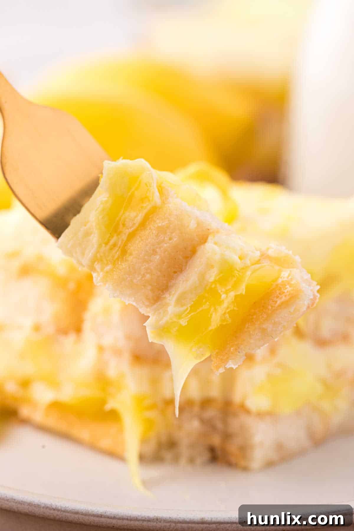 Italian Lemon Cloud 12 A fork holding a bite-sized piece of Lemon Tiramisu, showcasing its creamy texture.