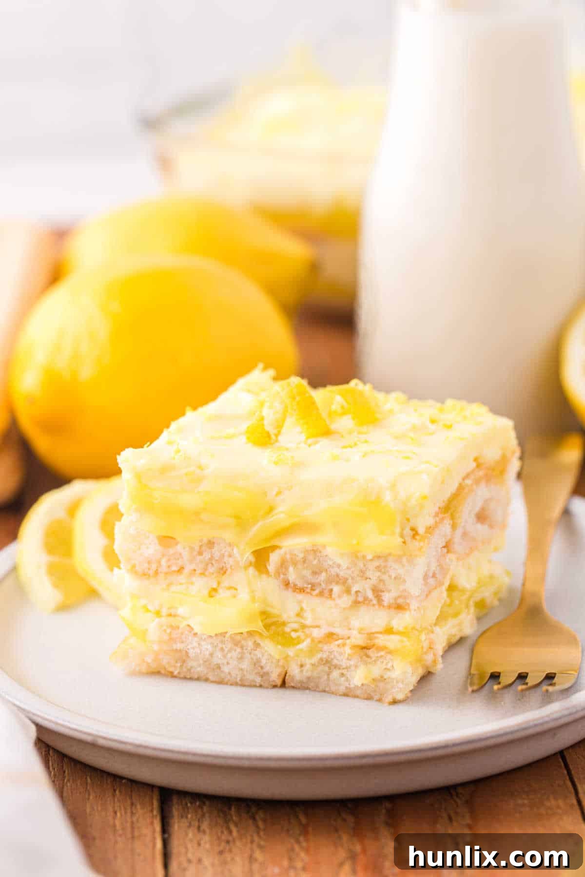 Italian Lemon Cloud 9 A single slice of Lemon Tiramisu on a white plate, ready to be enjoyed.