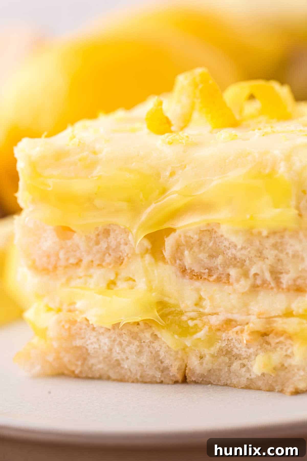 Italian Lemon Cloud 10 A perfectly portioned piece of Lemon Tiramisu on a pristine white plate.