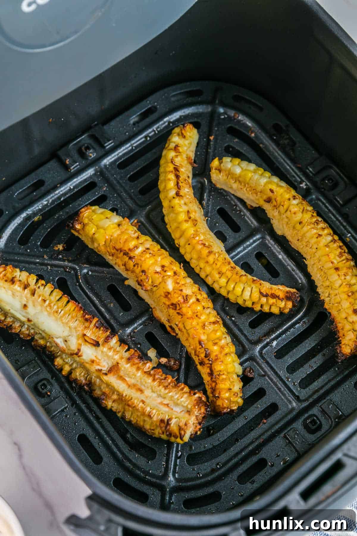 Corn ribs in an air fryer basket, perfectly cooked and lightly golden.