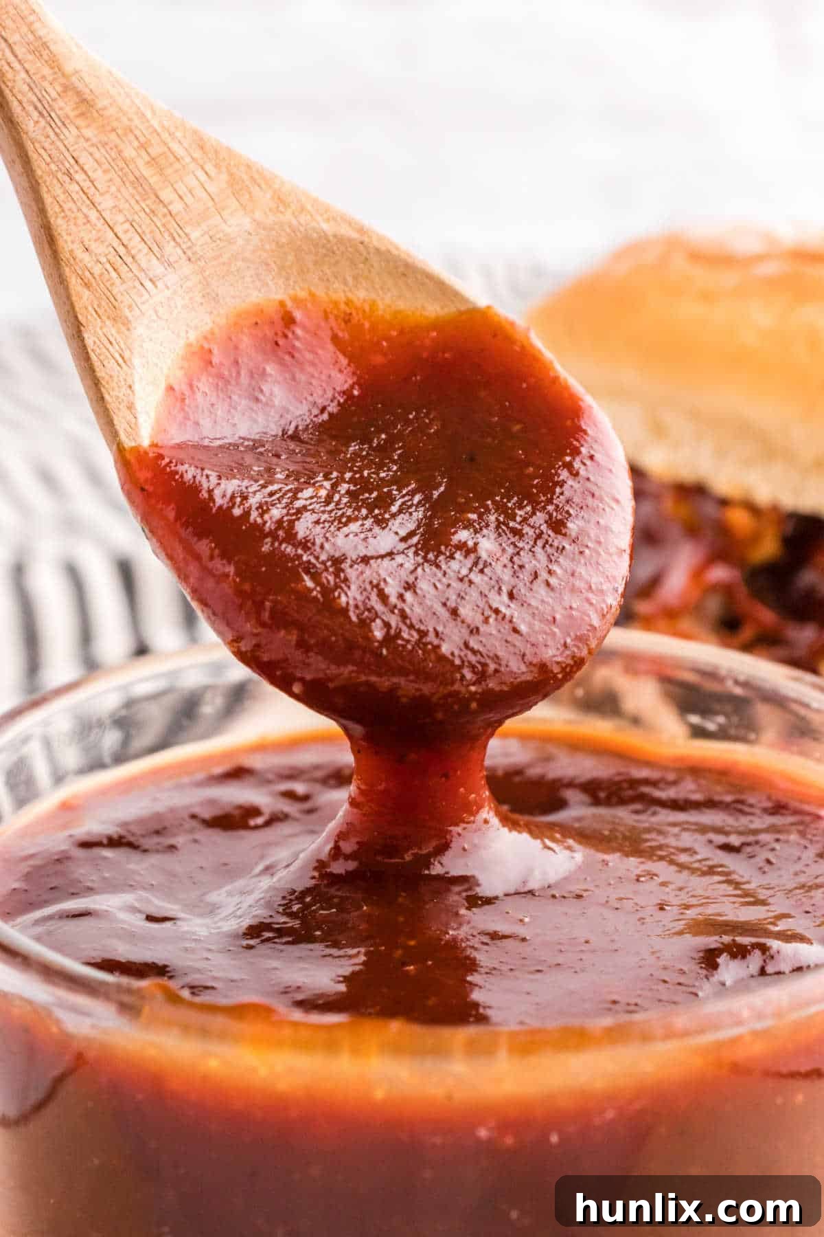 Signature Homemade BBQ Sauce 2 Homemade bbq sauce in a bowl with a wooden spoon.