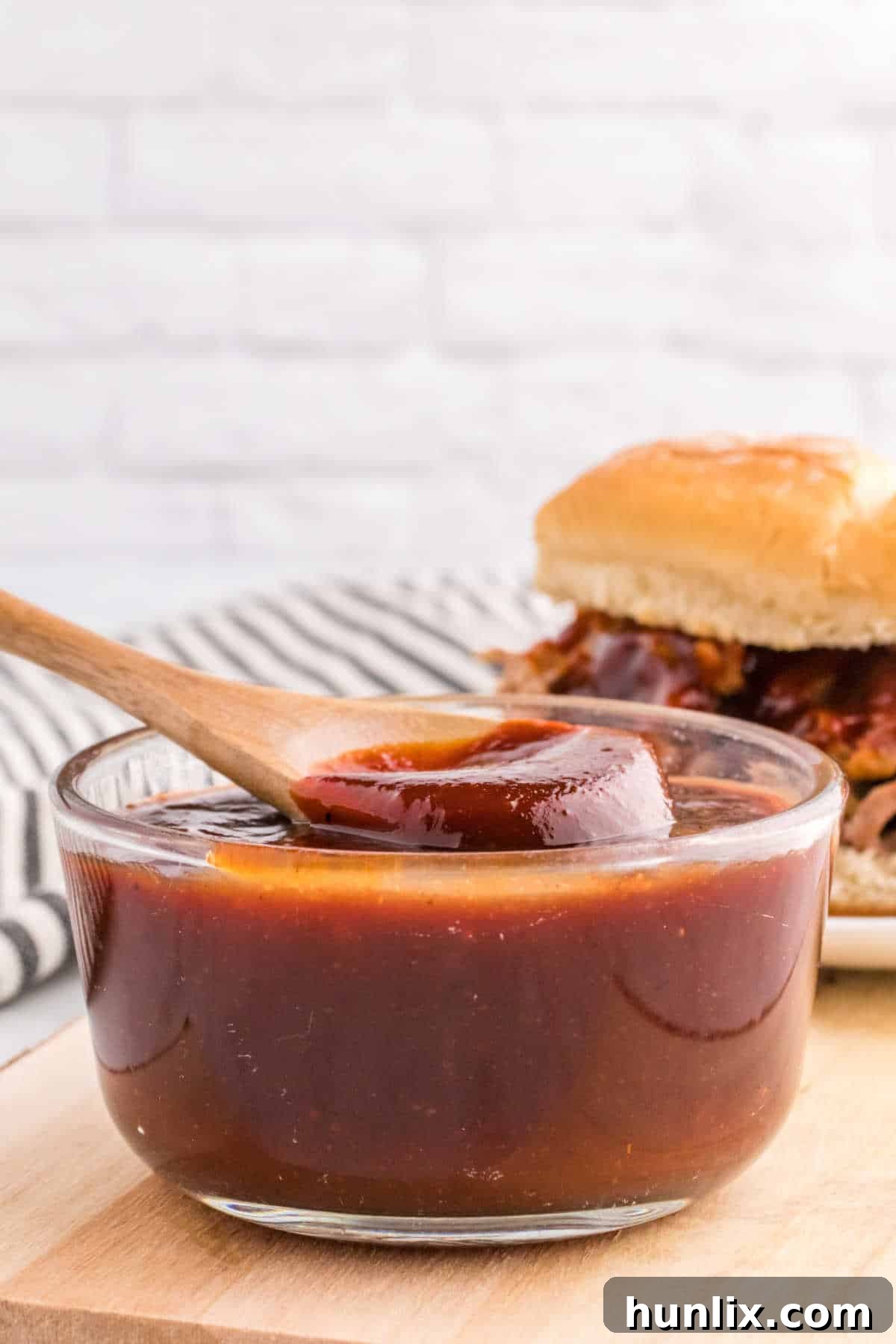 Signature Homemade BBQ Sauce 7 A bowl of homemade bbq sauce with a wooden spoon.