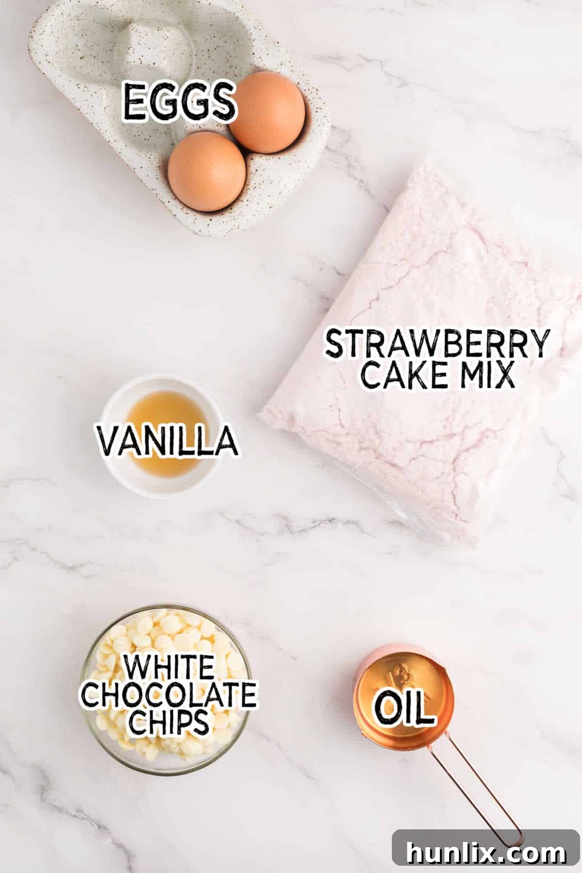 A collection of ingredients for strawberry cake mix cookies laid out on a surface.