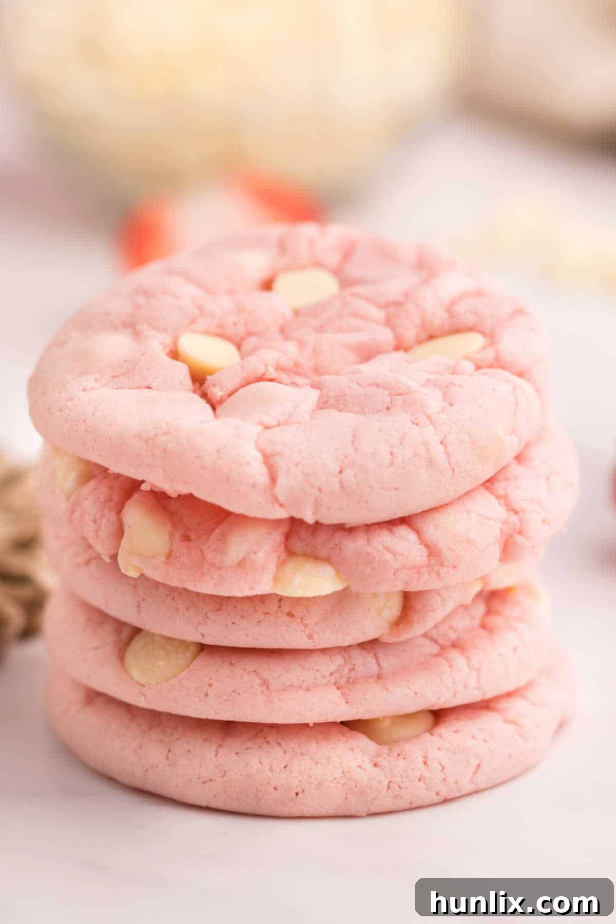 A stack of vibrant pink strawberry cake mix cookies on a clean surface.