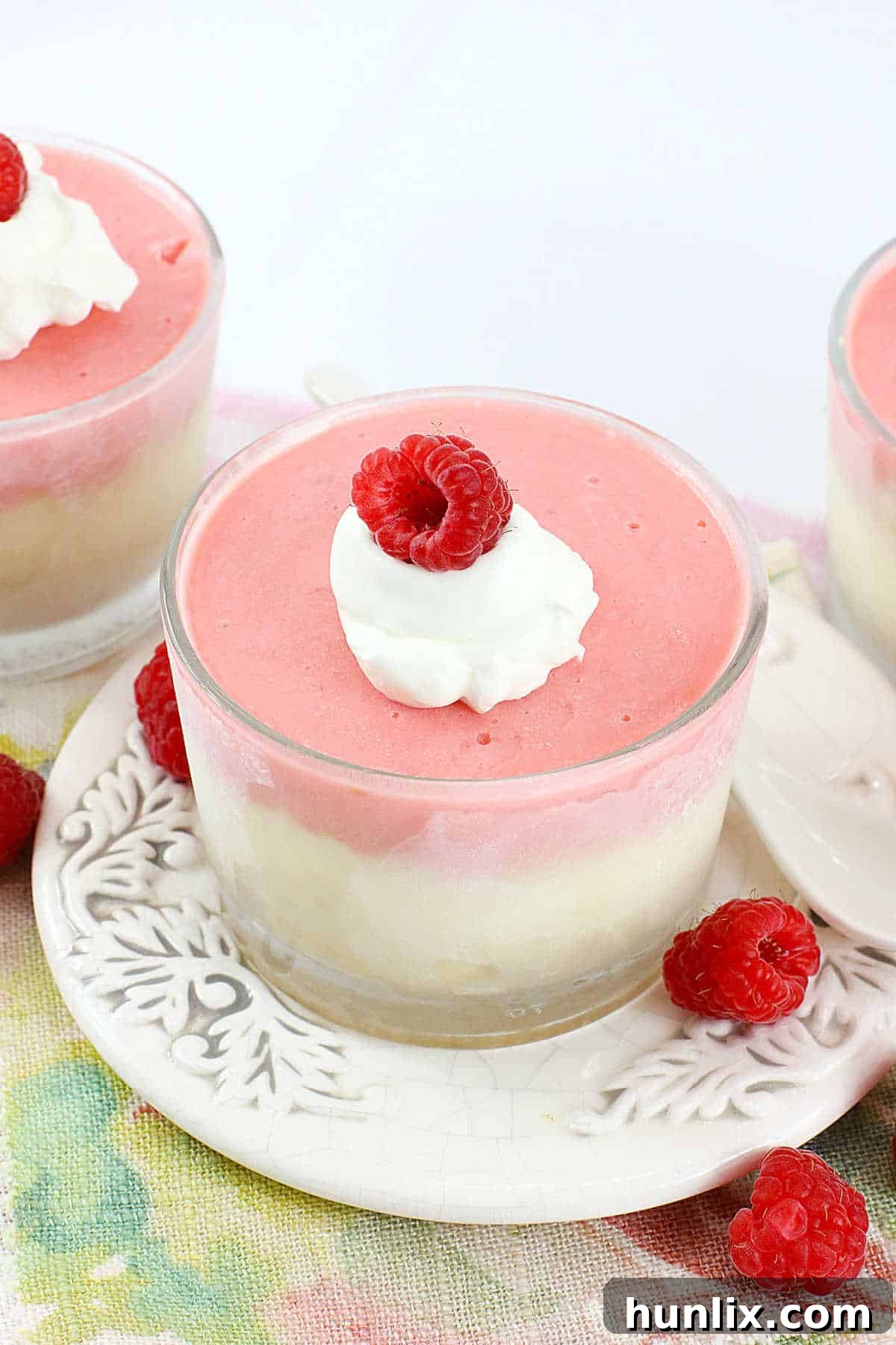 Raspberry cheesecake cups beautifully presented on a serving plate.