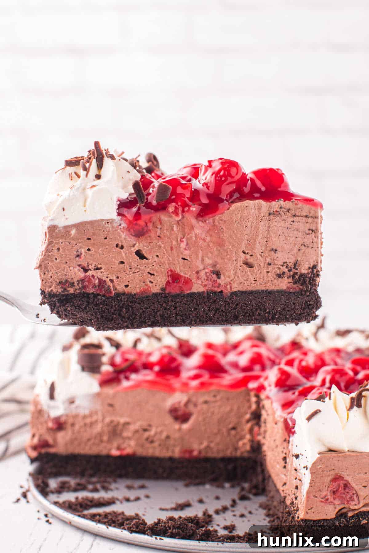 A slice of black forest cheesecake on a serving spatula, ready to be placed on a plate.