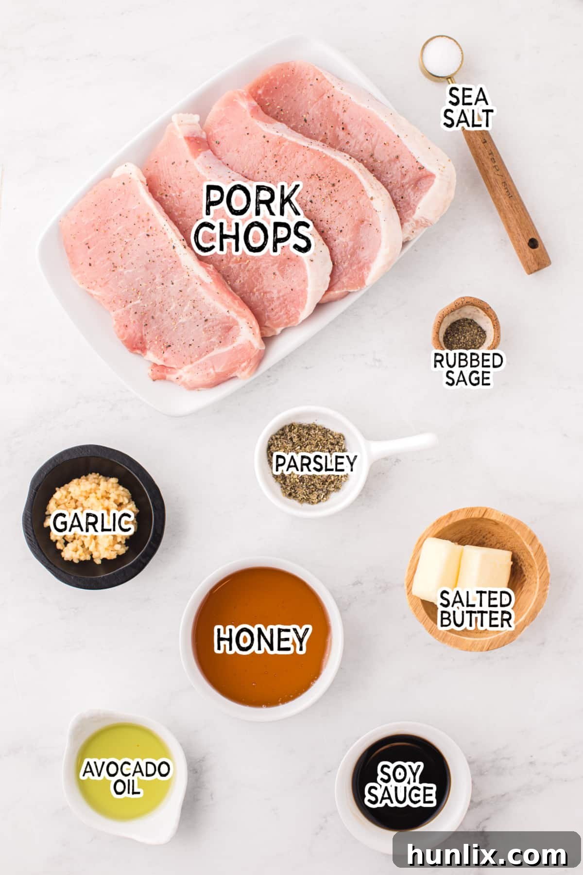 All the fresh ingredients laid out on a wooden board, ready for making honey garlic pork chops.