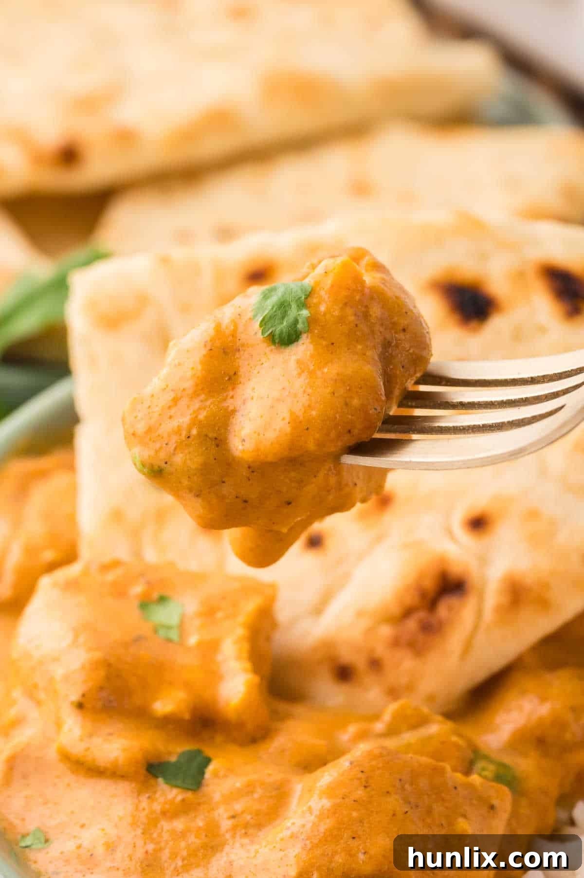 Butter chicken on a fork.