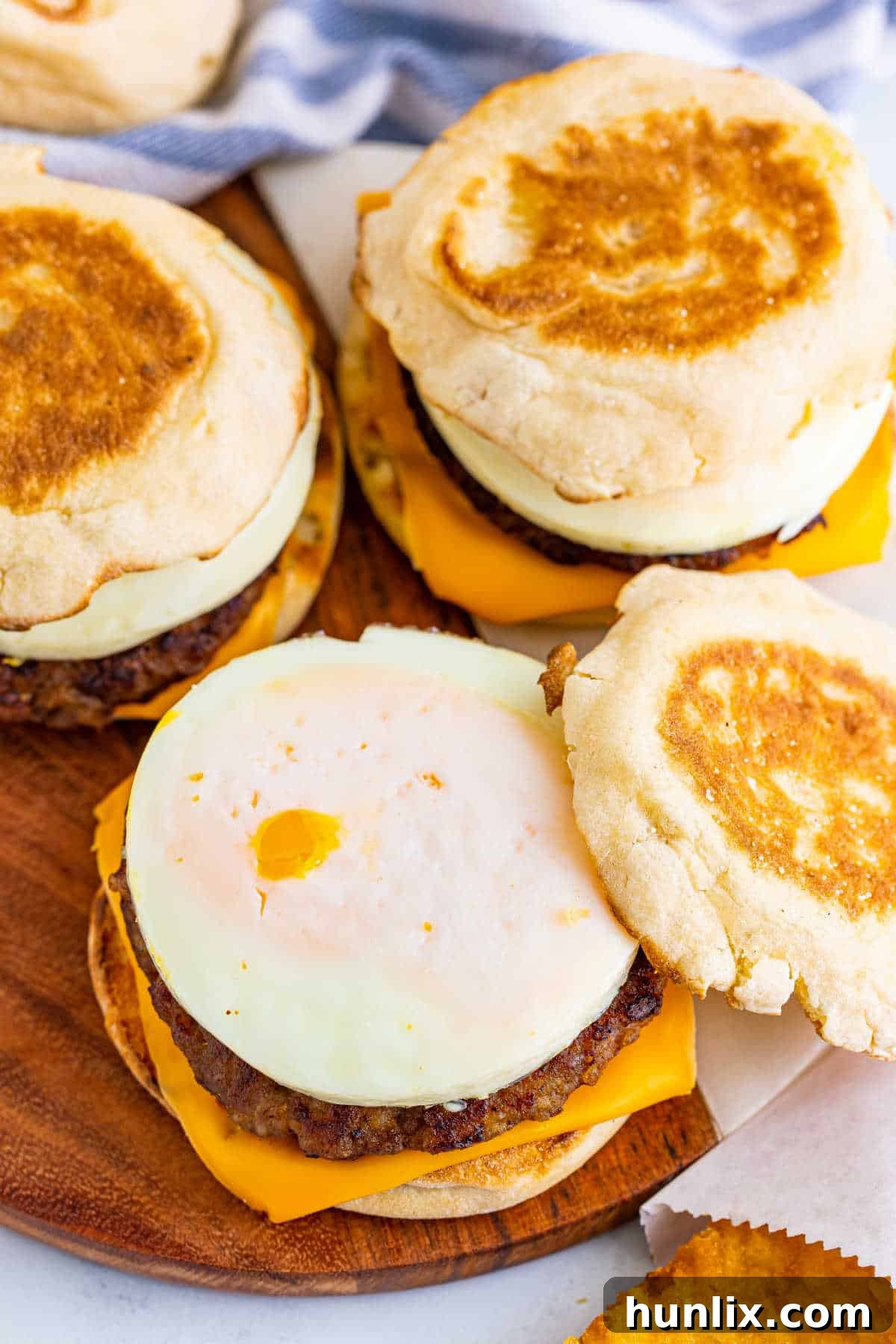 A group of breakfast sandwiches on a wooden surface.