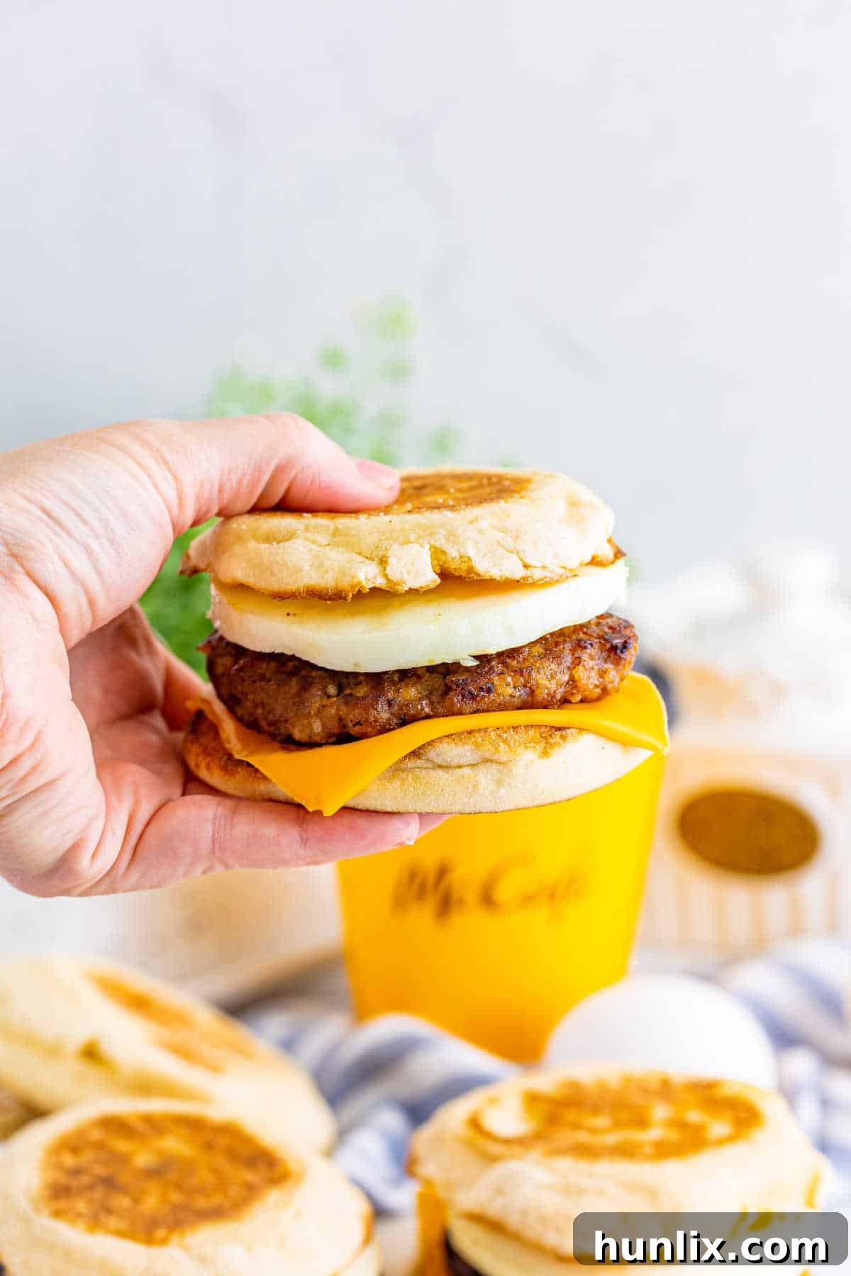 A hand holding a breakfast sandwich.