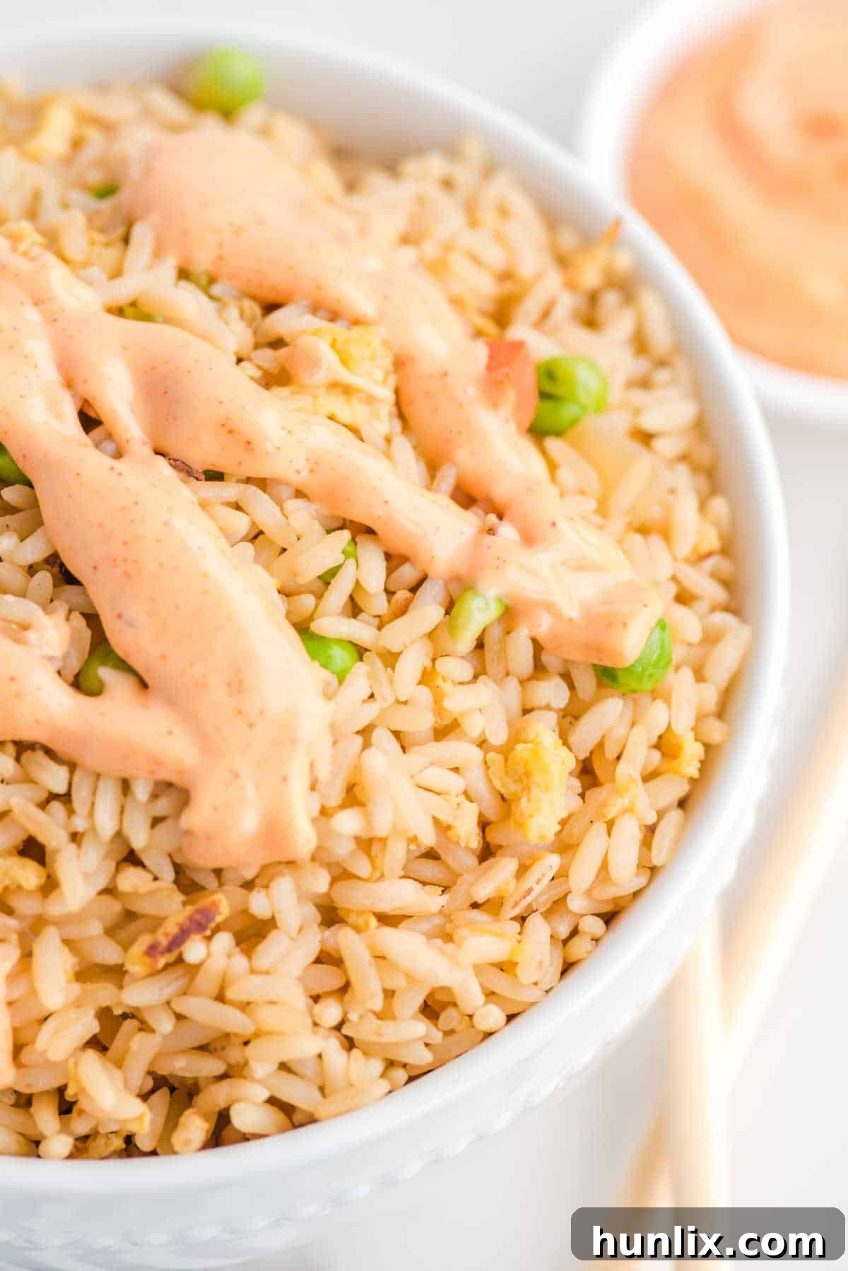 Yum Yum Sauce drizzled over a bowl of fried rice.