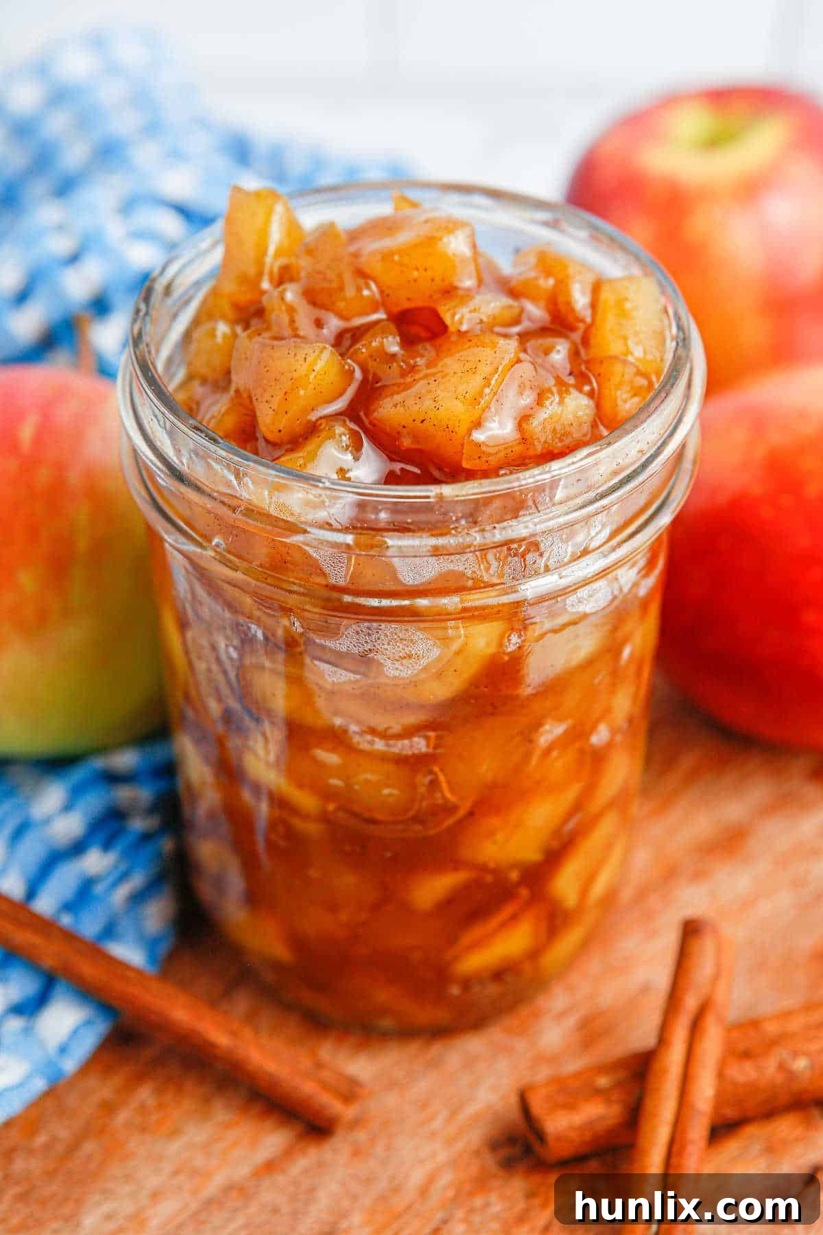 A glass jar elegantly showcasing a generous portion of chunky apple compote.