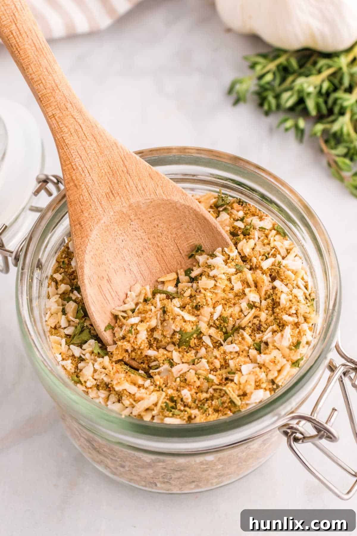 Aromatic Onion Seasoning 7 Homemade onion soup mix in a jar with a wooden spoon resting inside, ready for scooping.