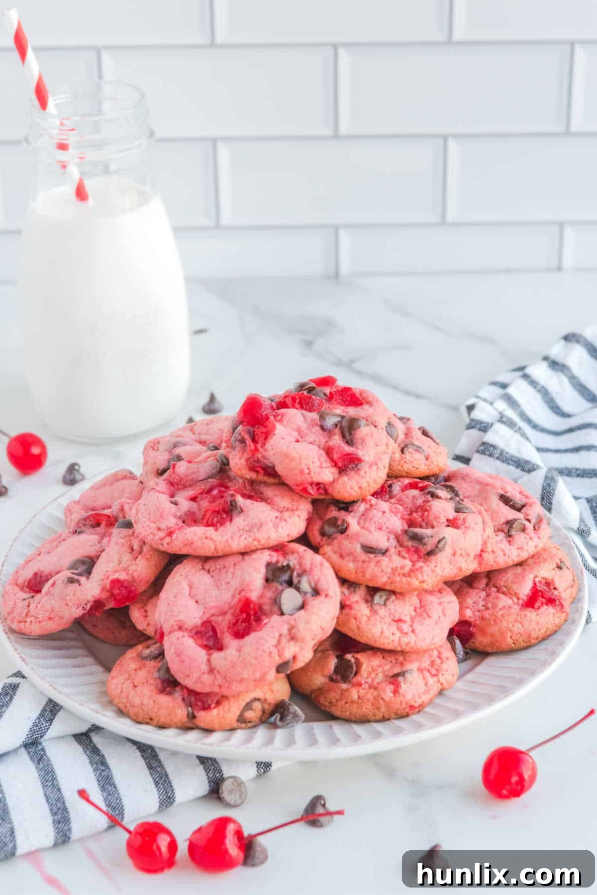 A pile of cherry cookies on a plate.
