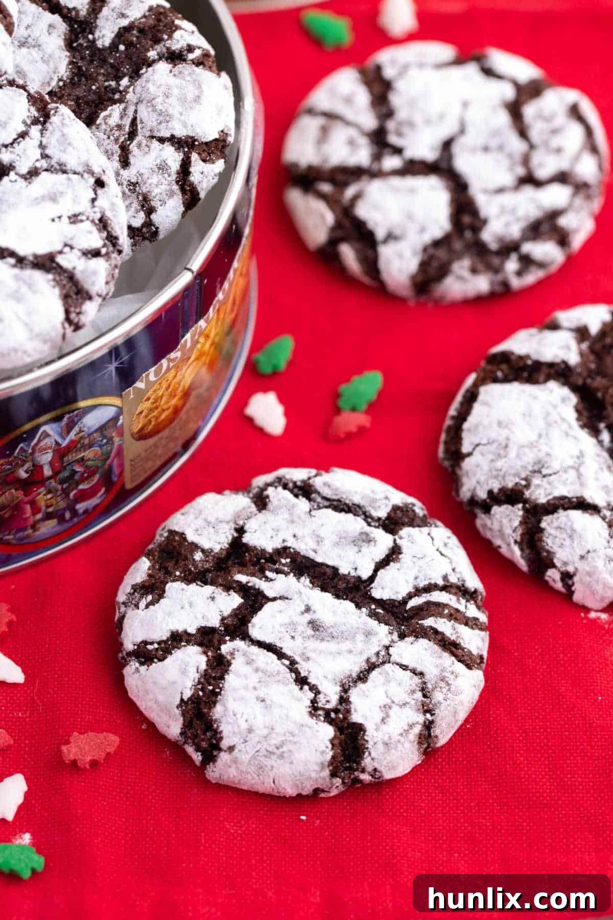 A single chocolate crinkle cookie resting on a vibrant red linen, showcasing its rich chocolate color and snowy powdered sugar coating with beautiful cracks.
