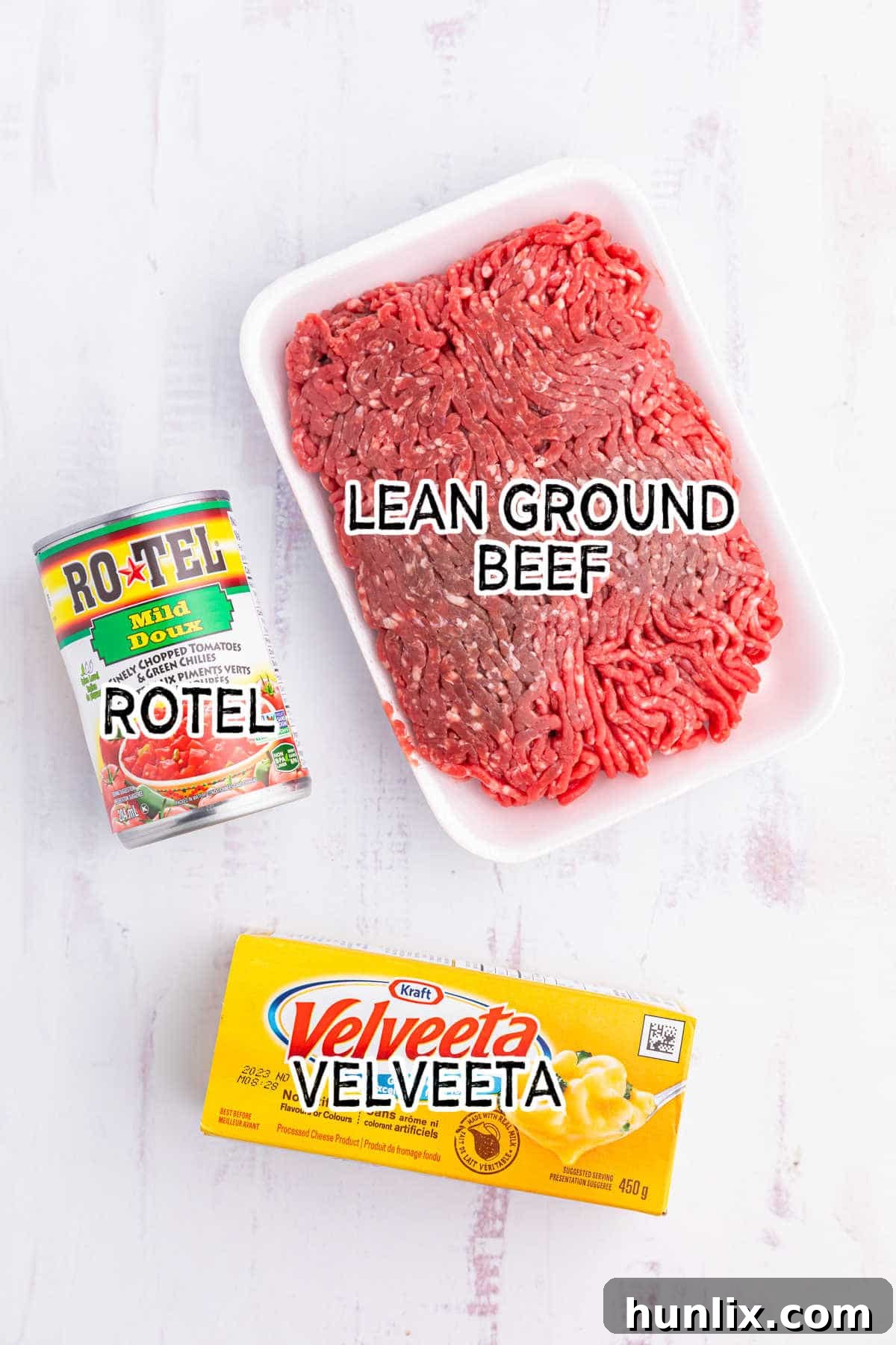 Ingredients laid out for making Rotel dip, including Velveeta, Rotel, and ground beef.