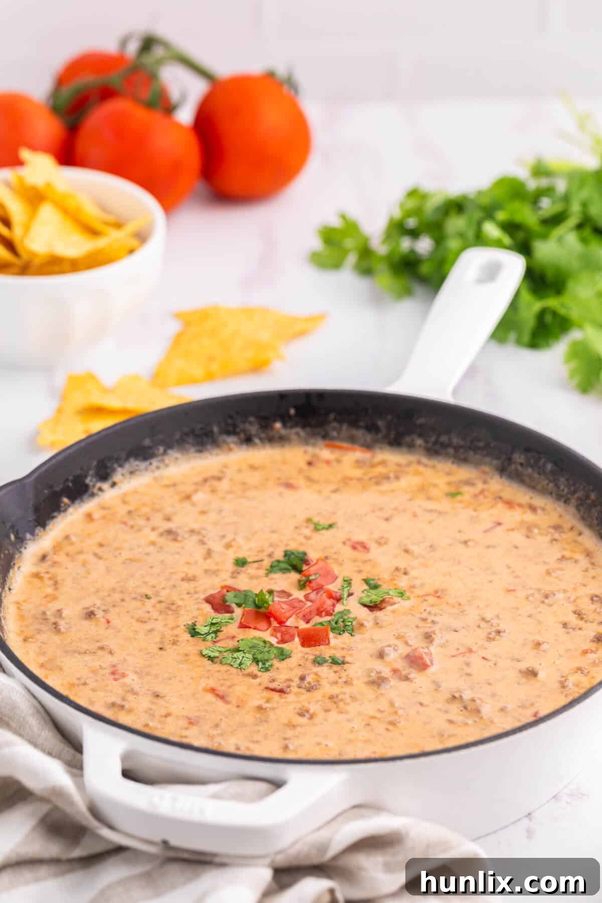 Rotel dip in a skillet, with a scoop removed.