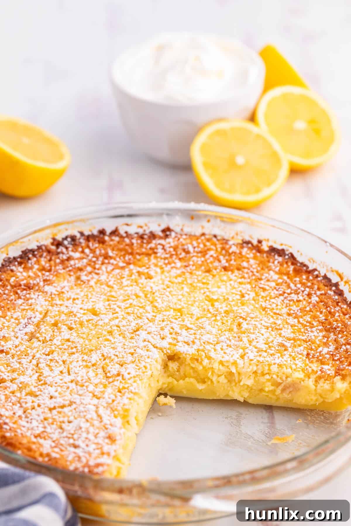 Slices of Lemon Impossible Pie with a few removed, showcasing the creamy texture and golden crust.