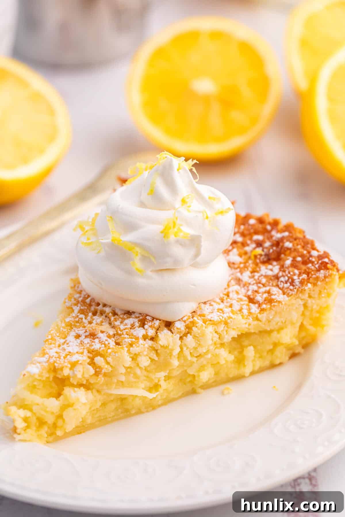 A slice of Lemon Impossible Pie on a white plate.