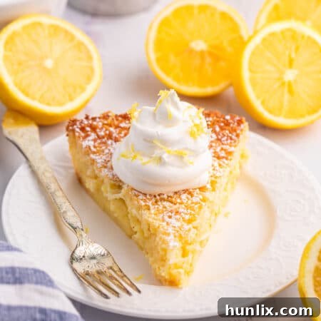 Close-up of a slice of Lemon Impossible Pie with a fork, showing the creamy texture and a hint of coconut.