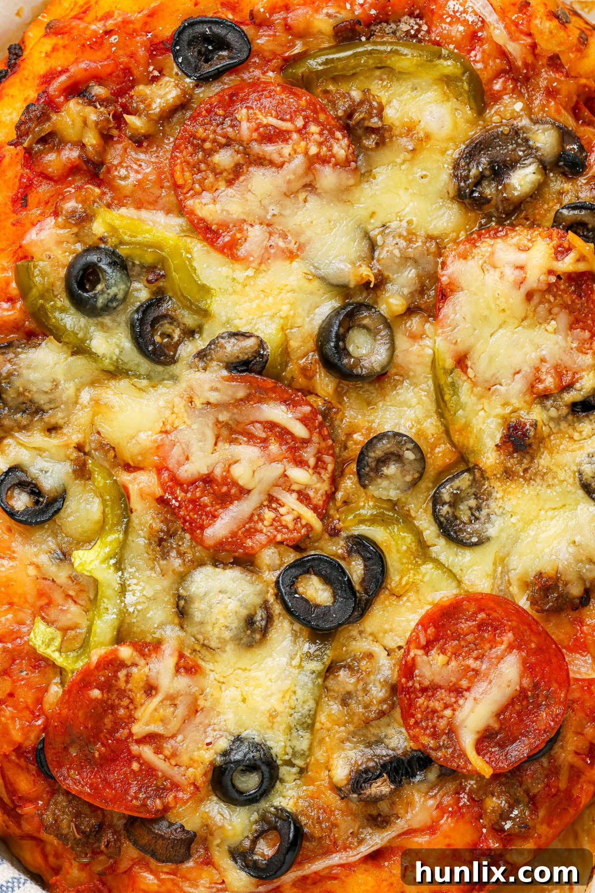 Close up shot of the toppings on a Crockpot supreme pizza, showing the melted cheese and fresh ingredients.