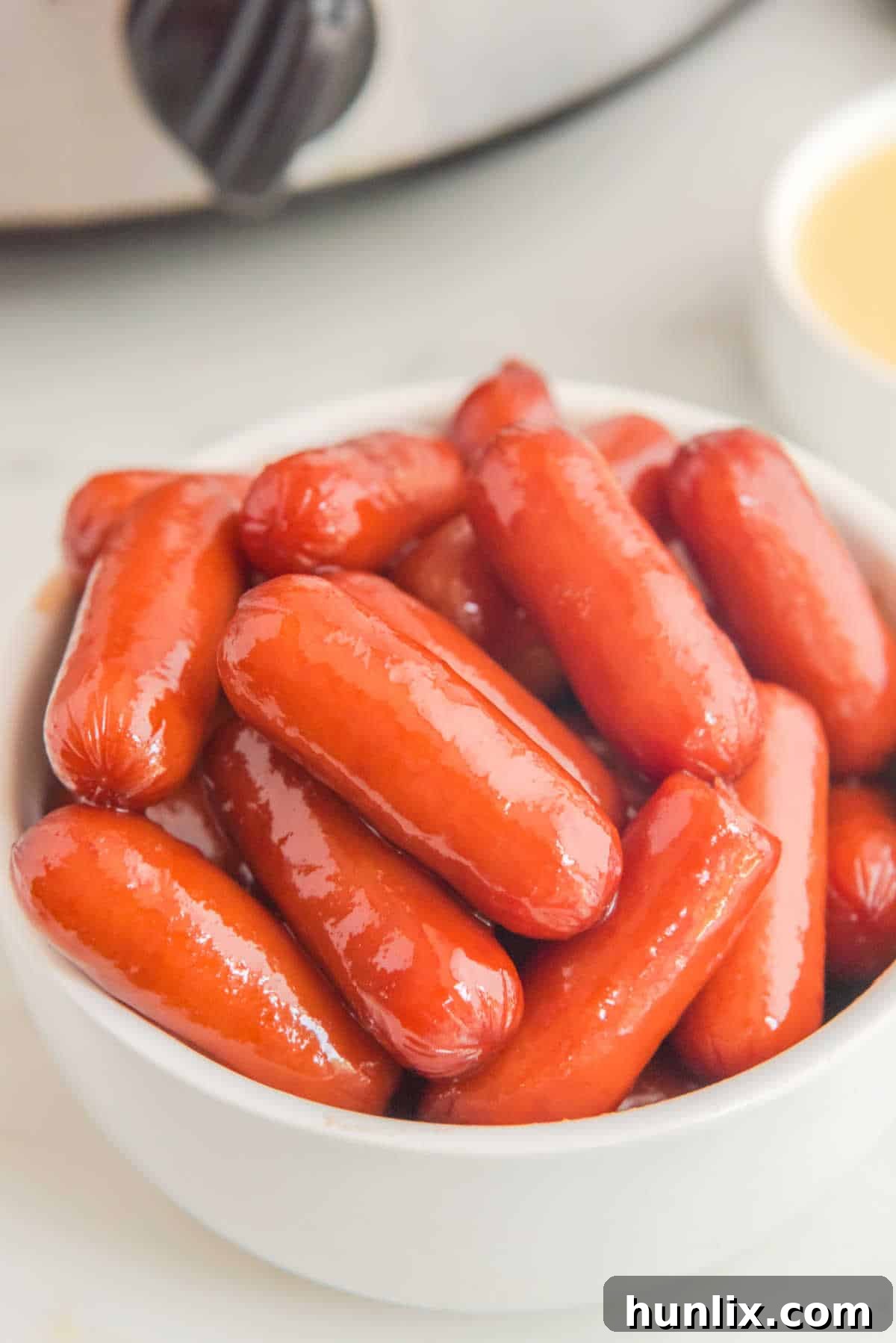 Little smokies in a white bowl.