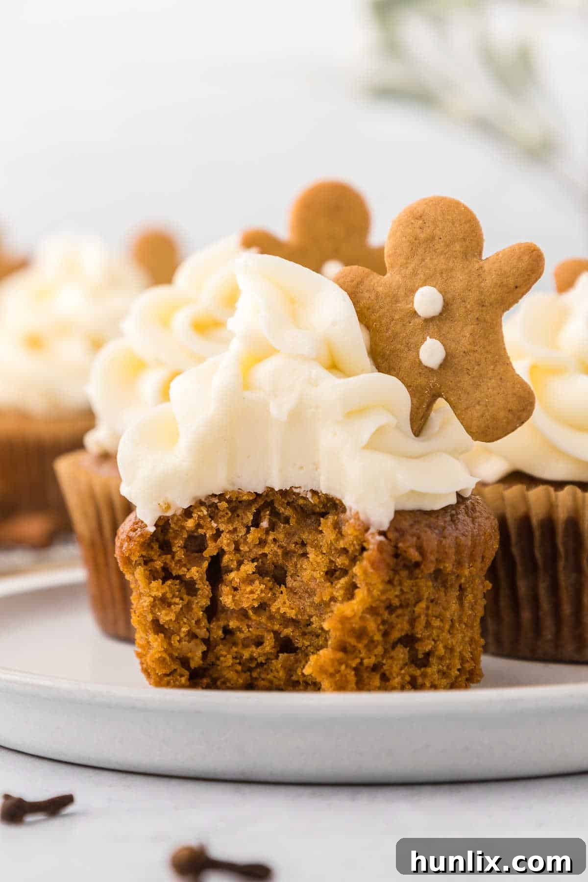 Molasses Ginger Cupcake Bliss 9 A gingerbread cupcake with a bite taken out, showing its moist interior and delicious frosting.
