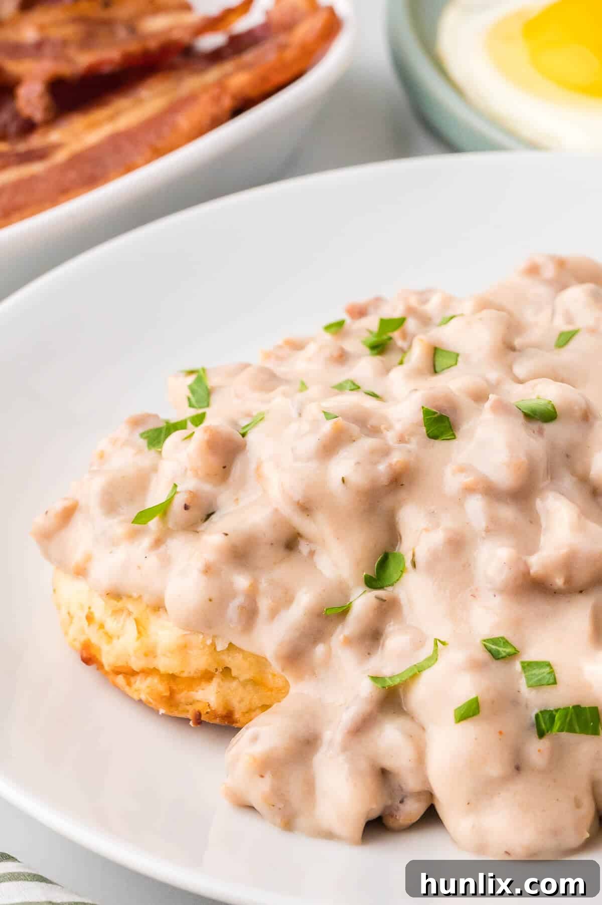 Sausage gravy over biscuits on a plate.