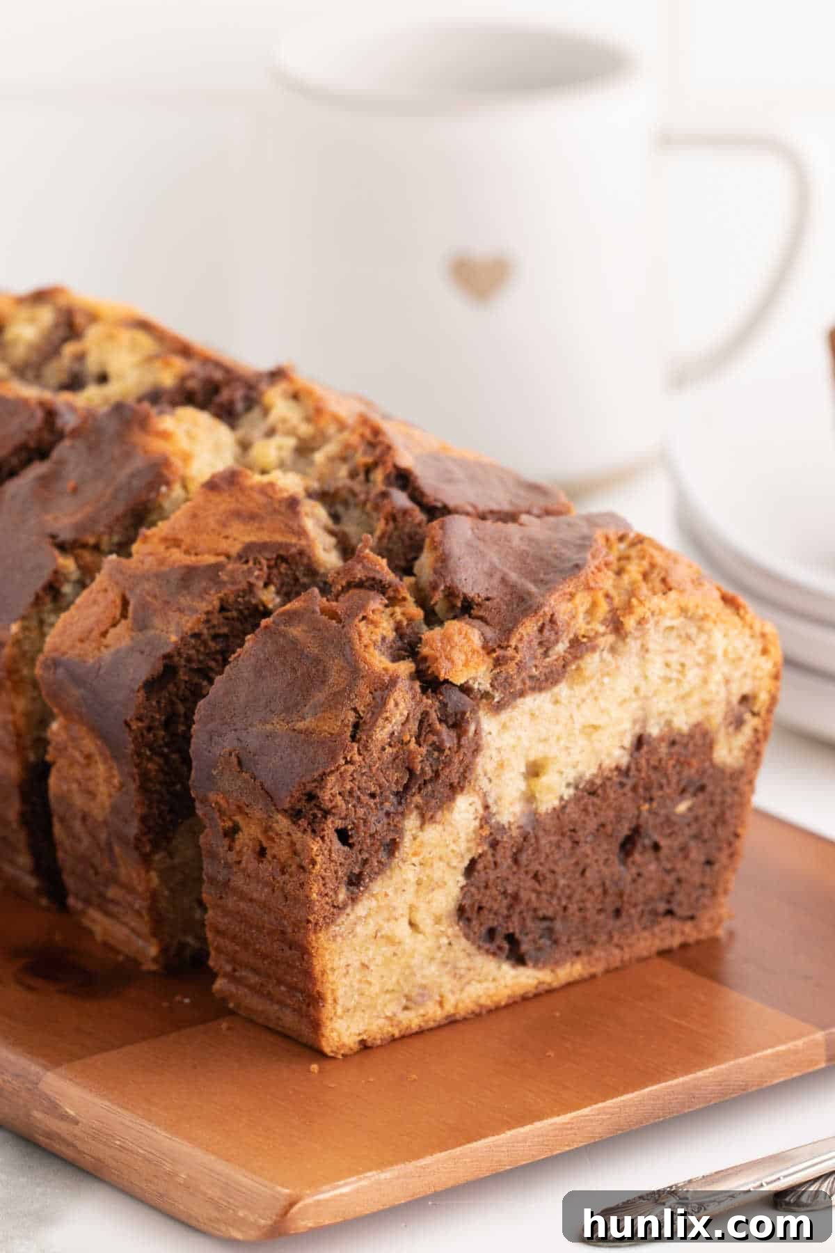 Beautifully marbled banana bread slices arranged on a rustic wooden cutting board.