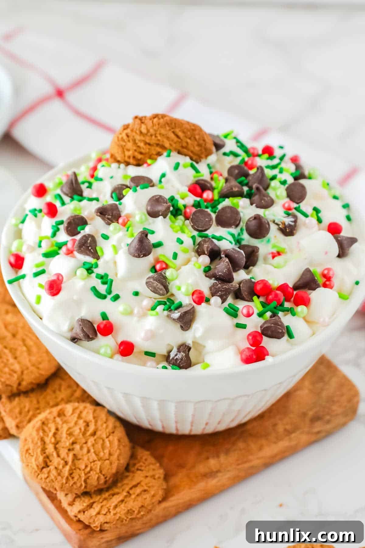 A bowl of white chocolate elf fluff, garnished with chocolate chips and Christmas sprinkles.