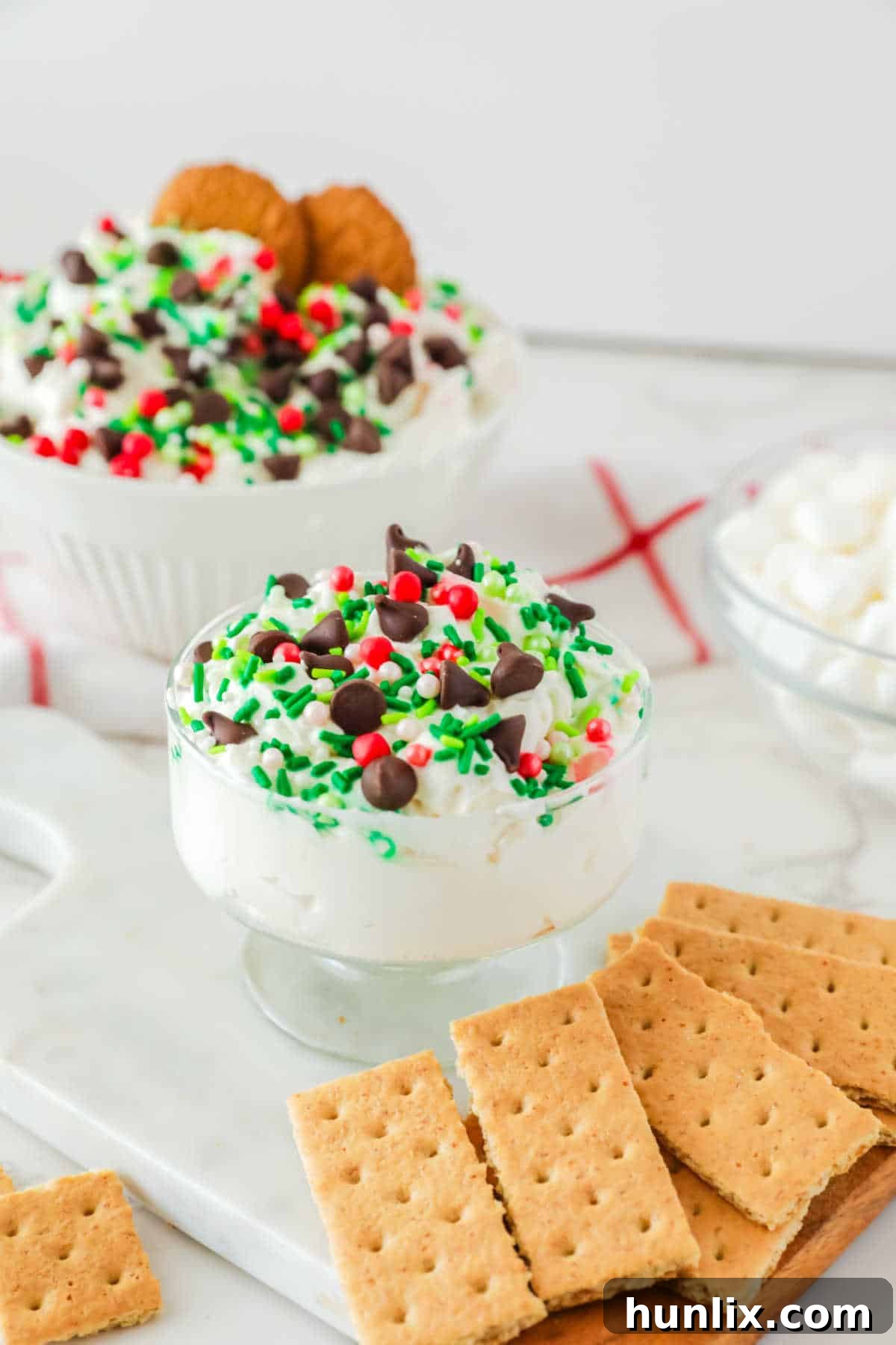 A large serving dish of White Chocolate Elf Fluff with various cookies around it.