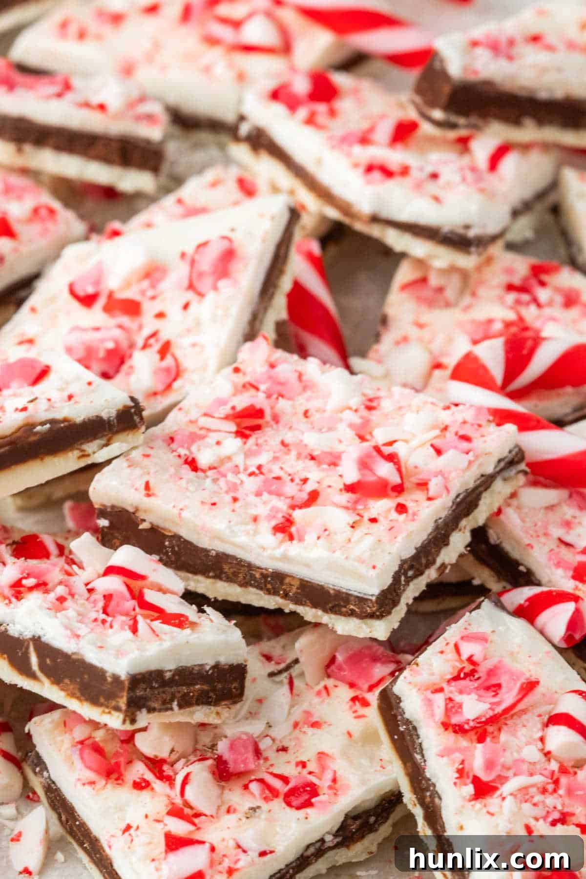 A beautifully arranged pile of homemade peppermint bark, showcasing its distinct layers and festive candy cane sprinkles.