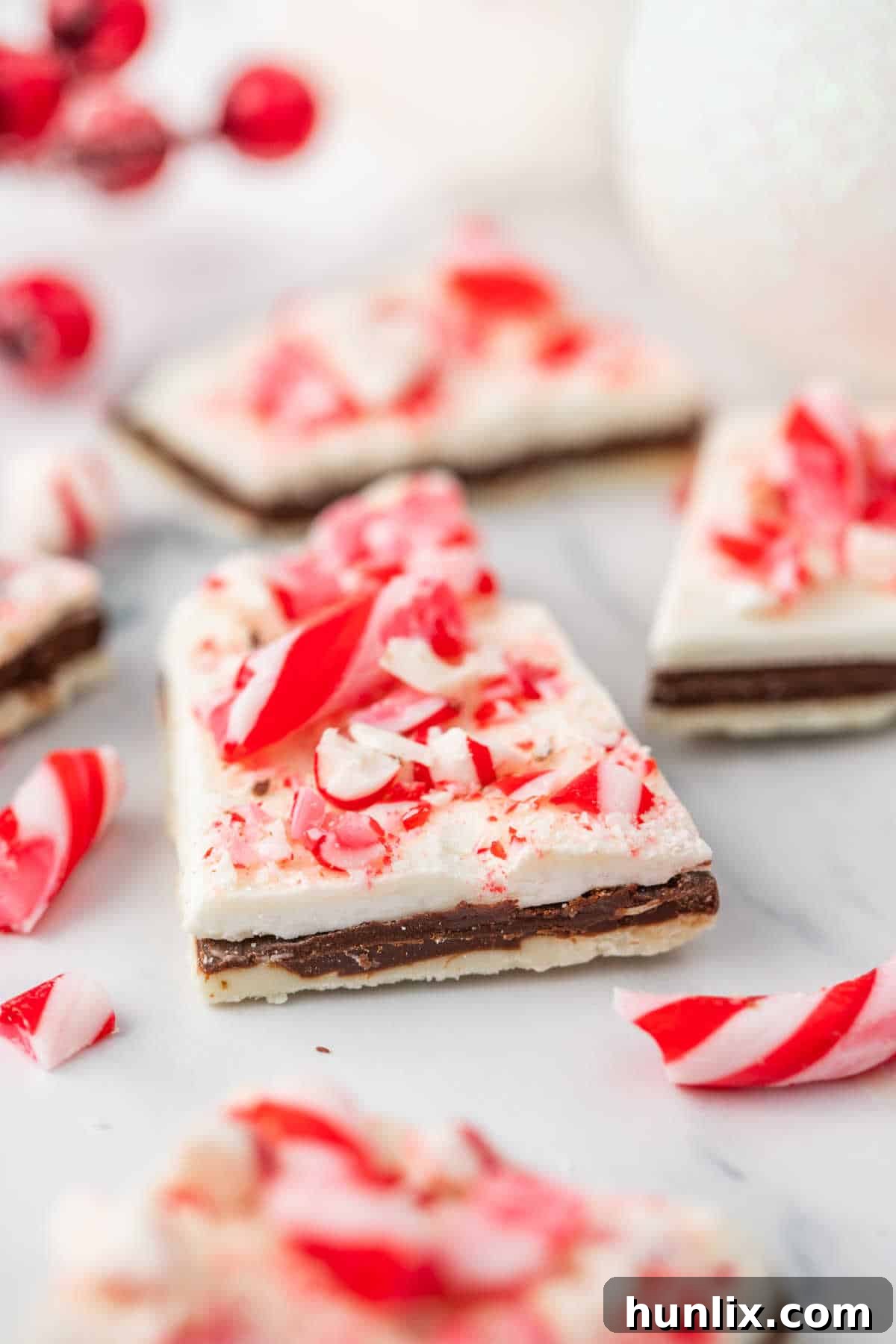 A close-up of finished peppermint bark laid out on a clean white surface, highlighting its vibrant color and texture.
